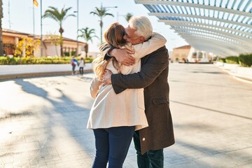 Sticker - Middle age man and woman couple hugging each other standing at park