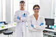 © Krakenimages.com - Man and woman partners wearing scientist uniform standing with arms crossed gesture at laboratory