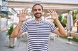 © Krakenimages.com - Young hispanic man with beard outdoors at the city showing and pointing up with fingers number ten while smiling confident and happy.