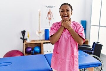 Wall Mural - Young african american woman working at pain recovery clinic shouting and suffocate because painful strangle. health problem. asphyxiate and suicide concept.