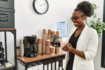 Canvas Print - African american woman business worker pouring coffee on cup at office