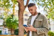 © Krakenimages.com - Young hispanic man smiling confident using smartphone at park