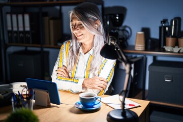 Sticker - Middle age woman with grey hair working at the office at night happy face smiling with crossed arms looking at the camera. positive person.