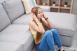 © Krakenimages.com - Young caucasian woman listening to music sitting on floor at home