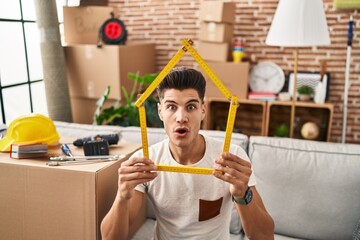 Sticker - Young hispanic man moving to a new home afraid and shocked with surprise and amazed expression, fear and excited face.