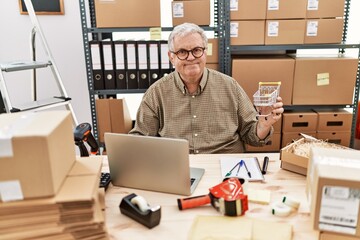 Sticker - Senior caucasian man working at small business ecommerce holding shopping cart looking positive and happy standing and smiling with a confident smile showing teeth