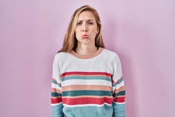 Sticker - Young blonde woman standing over pink background depressed and worry for distress, crying angry and afraid. sad expression.