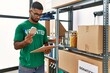 © Krakenimages.com - Young arab man wearing volunteer uniform holding canned food at charity center