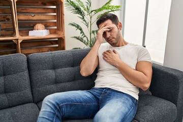 Wall Mural - Young hispanic man stressed having mental therapy sitting on sofa at psychology center