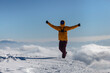 © almostfuture - Happy hiker enjoys the view on cliff edge top of the winter mountain