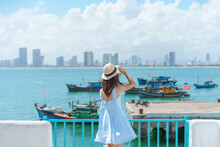Woman Traveler Visiting At Son Tra Marina. Tourist With Blue Dress And Hat Traveling In Da Nang City. Vietnam And Southeast Asia Travel Concept