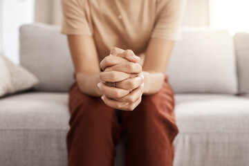 Stress, worry and hands of woman on sofa with mental health issue, problem and anxiety at home. Depression, sadness and close up of connected hand of girl with fear, nervous and stressed expression