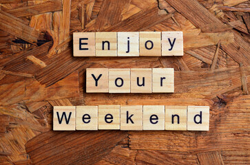 enjoy your weekend text on wooden square, holiday concept quotes