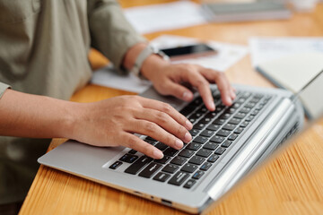 Aufkleber - Selective focus on right hand of young female employee and keyboard of laptop during online communication or network by workplace