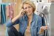worried young woman talking on mobilephone in kitchen
