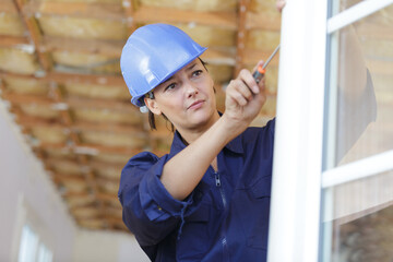 woman fixing old wooden white window panel