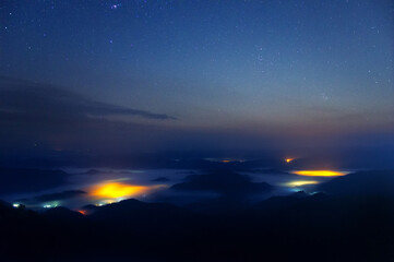 Wall Mural - night view and cold atmosphere with fog over samoeng district, seen from mon chaem viewpoint, chiang