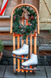 Figure ice skates, wooden sledge, Christmas wreath. Vintage wintertime holidays equipment, street decor