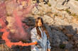 © Westend61 - Girl holding distress flare in front of mountain