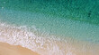 © DenisProduction.com - Aerial view of turquoise ocean waves and sandy beach. Top view of foamy waves on yellow sandy coastline. Vacation on tropical island.