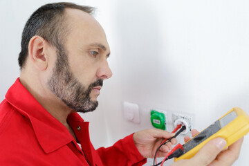 an electrician checking socket voltage