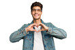 © Asier - Young caucasian handsome man isolated smiling and showing a heart shape with hands.
