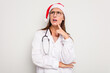 © Asier - Young caucasian doctor woman wearing a santa hat isolated on white background