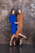 © Andrey_Arkusha - Two young girls in knitted plain dresses posing in the studio