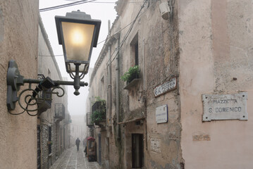 Wall Mural - Foggy narrow stone street.