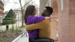 © Marco - Happy Interracial couple. Young woman jumping into boyfriend arms at park