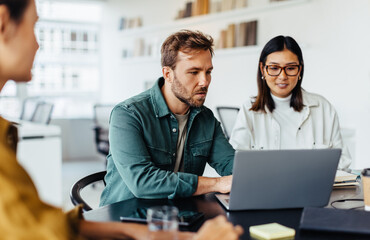 Poster - Business man using a laptop in a meeting with his team