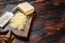 Piece Of Semi Hard Cheese And Grated Cheese With Grater. Wooden Background. Top View. Copy Space