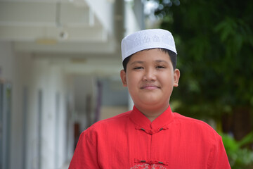 Wall Mural - Portrait young southeast asian islamic or muslim boy in white shirt and hat, isolated on white, soft and selective focus.