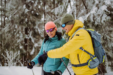 Senior Couple Checking Smartwatch During Winter Skiing.