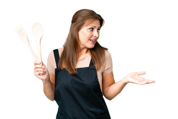 Canvas Print - Middle age caucasian woman holding a rolling pin over isolated background with surprise expression while looking side