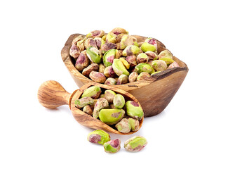 Wall Mural - Shelled Pistachios in closeup isolated. Nuts  in wooden spoon on white background