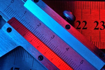 Wall Mural - caliper and metal rulers illuminated in red and blue. close-up