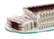 Viennetta-type ice cream cake, whipped cream with cocoa and chocolate flakes, sliced on a glass tray
