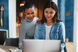 © Flamingo Images - Smiling young female entrepreneurs using a laptop in a cafe