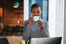 Young Female Entrepreneur Working In A Cafe And Drinking Coffee