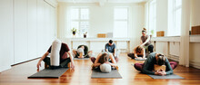 Restorative Yoga Teacher Helping Students In Class