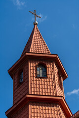 Wall Mural - Metal cross with roof tiles in the blue sky background. Ukraine