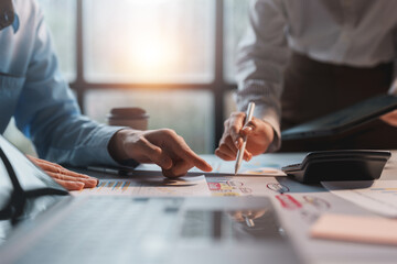 Wall Mural - Business team jointly plan the investment at the meeting. Close-up of businesspeople pointing at graph and chart recording and analyzing financial reports with calculator.