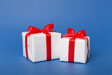Fototapeta  - Gift boxes with red ribbon bow on color background