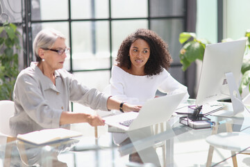 Software development team discussing algorithms on computer screen in office