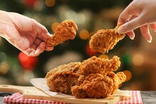 People Hands Taking The Fried Chicken Wings By Hands,Christmas Night Dinner.
