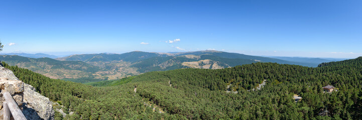 Panoramic view of high mountains covered by green pine forest in Neila lagoons natural park at daylight, Neila, Burgos, Spain