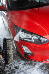 Wall Mural - Front lights of a red car being washed.