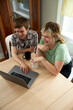 © Matthew Liteplo/Adobe Stock - Non Binary LGBTQ+ Couple looking at computer in apartment