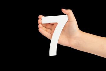 Aufkleber - Number seven in hand isolated on black background. Number 7 in a child's hand on a black background. To be inserted into a project or design.